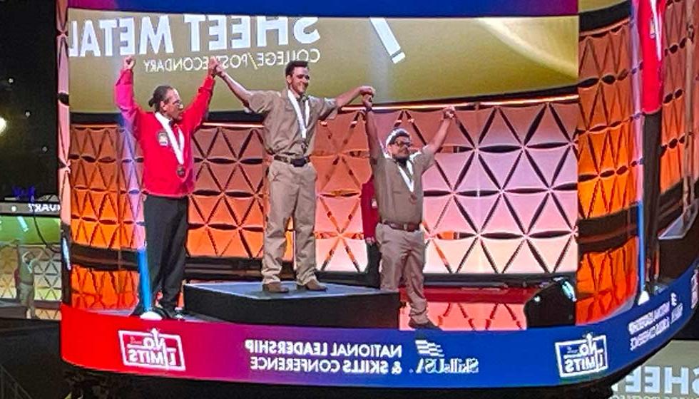 Video scoreboard with students on a medal podium, text: Sheet Metal - SkillsUSA National Leadership and Skills Conference - No limits